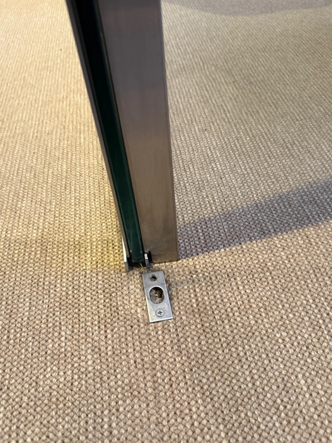 Floor-level lock and pivot fitting on a glass door in NYC