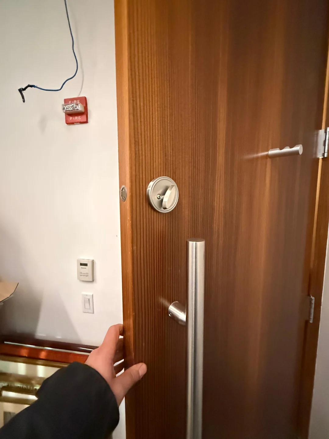 Checking the door edge and deadbolt before installing a reinforced strike plate in NYC