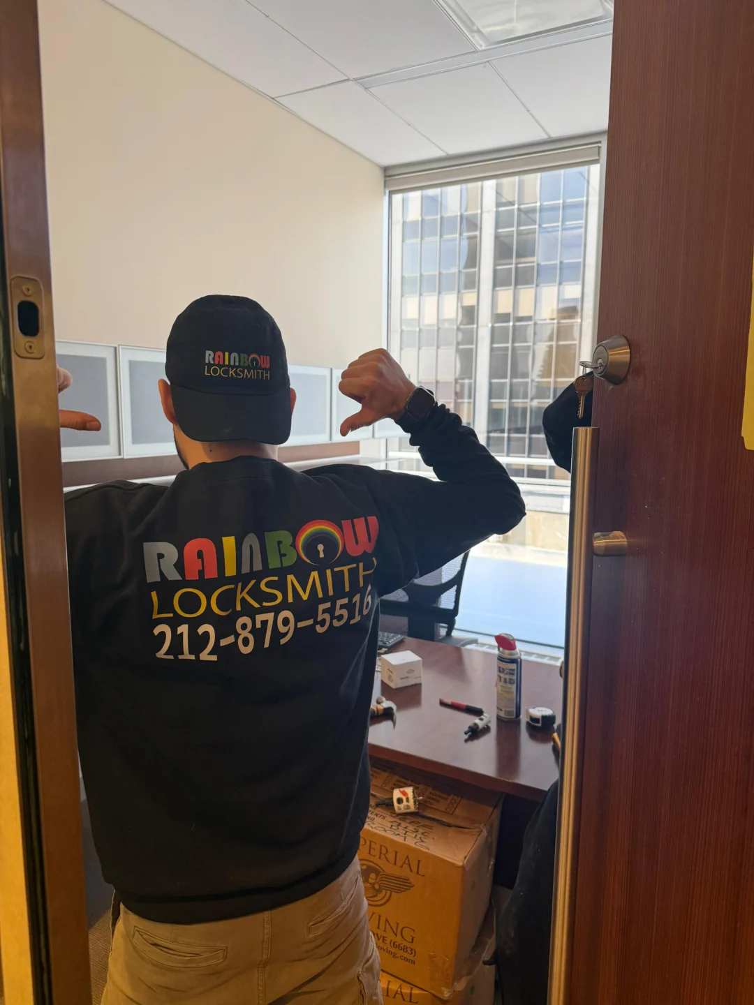 Rainbow Locksmith technician installing a renter-friendly lock in an NYC apartment building